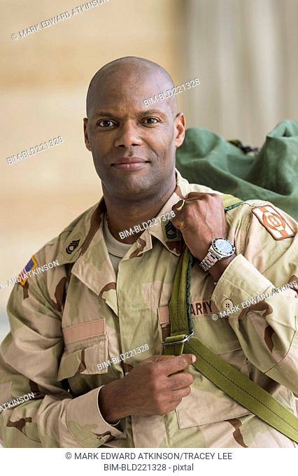 African American soldier carrying duffel bag