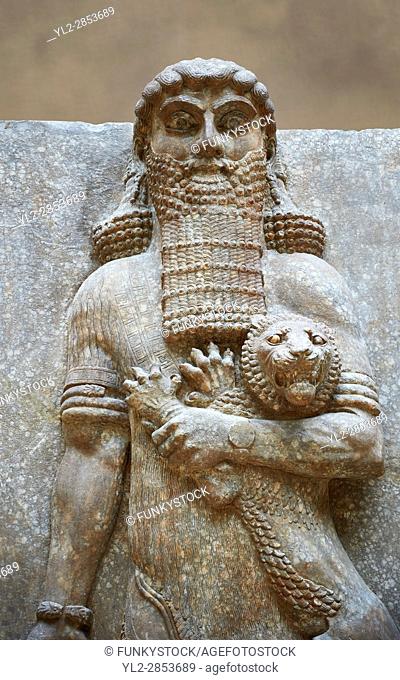 Stone relief sculptured panel of a Hero holding a lion. From the facade of the throne room, Inv AO 19862 from Dur Sharrukin the palace of Assyrian king Sargon...
