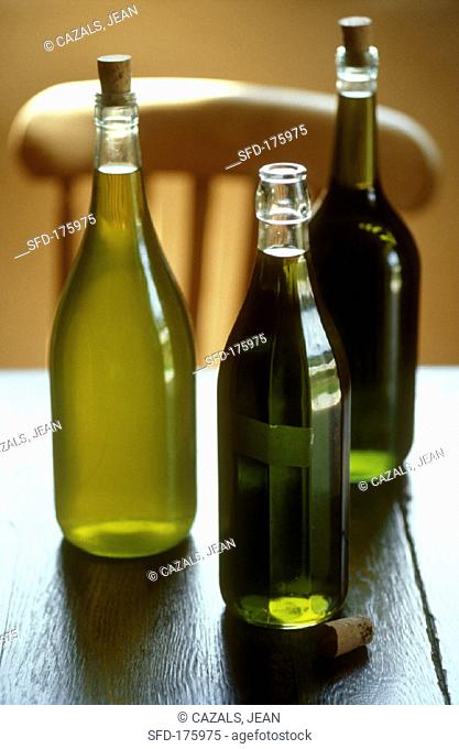 Three different olive oils on wooden table