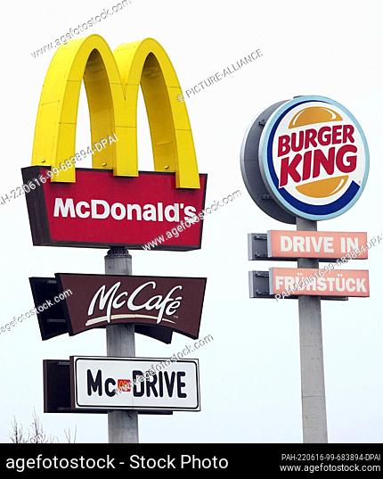 30 April 2022, Schleswig-Holstein, ---: The logos of Mcdonald's and McCafe as well as Burger King stand next to the respective fast food restaurants at a...