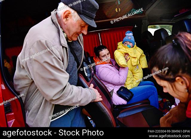 04 March 2022, Hungary, Tiszabecs: People fleeing war and Russian aggression from Ukraine arrive at a shelter for refugees on the border with Ukraine by bus in...
