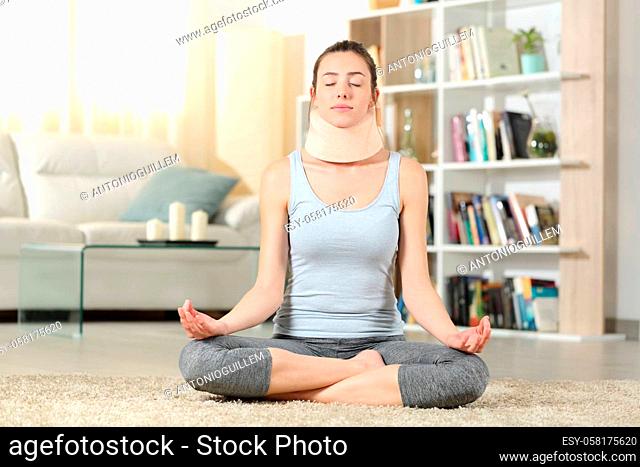 Front view portrait of a disabled woman with neck brace doing yoga exercise at home