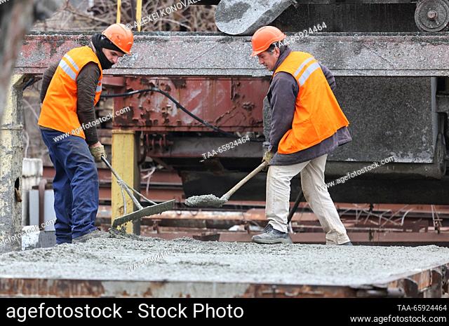 RUSSIA, ZAPOROZHYE REGION - DECEMBER 19, 2023: Employees level fresh concrete at a plant of reinforced concrete structures in the city of Berdyansk
