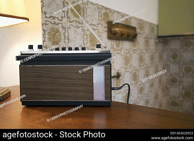 Retro vintage radio in 70s style living room, The FM channel is playing music, a stylish retro radio player stands on a wooden table