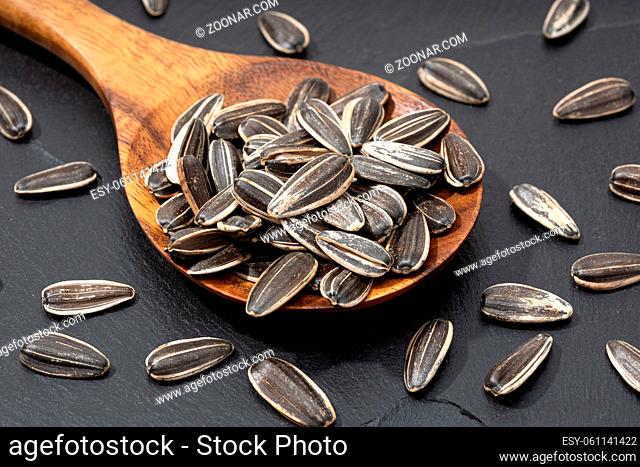 Sunflower Seeds in spoon on black slate. Helianthus seed