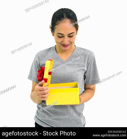 Asian middle-aged woman in gray t-shirt enjoy opening a gift box received for a special occasion. Portrait on white background with studio light