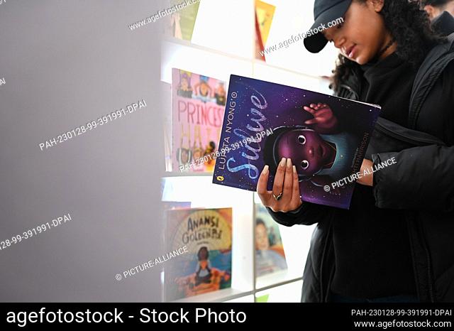 28 January 2023, Bremen: A visitor looks at a book in the new children's library. A children's and youth library that exclusively offers literature about the...
