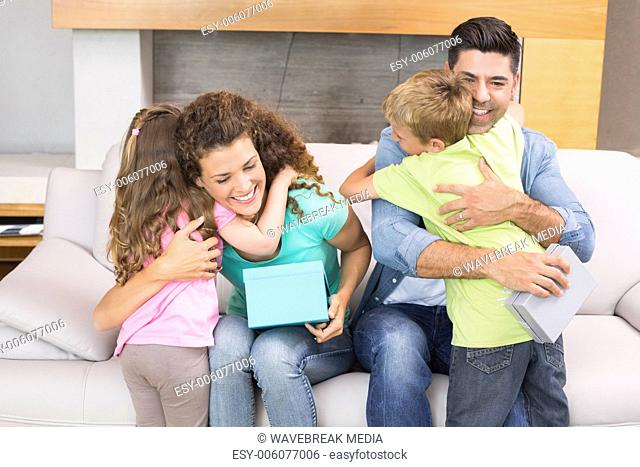 Young siblings giving presents to their parents
