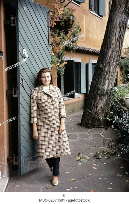 Princess of Iran Soraya (born Soraya Esfandiary-Bakhtiari), the second wife and Queen Consort of the late Shah of Iran, is leaning on the wood entry gate of her...