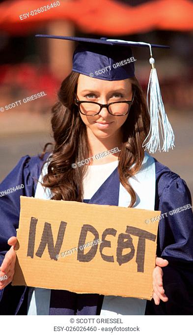 Single graduate with eyeglasses female holding debt sign
