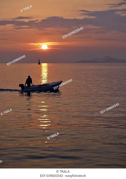 Fisherman at sunset returns home