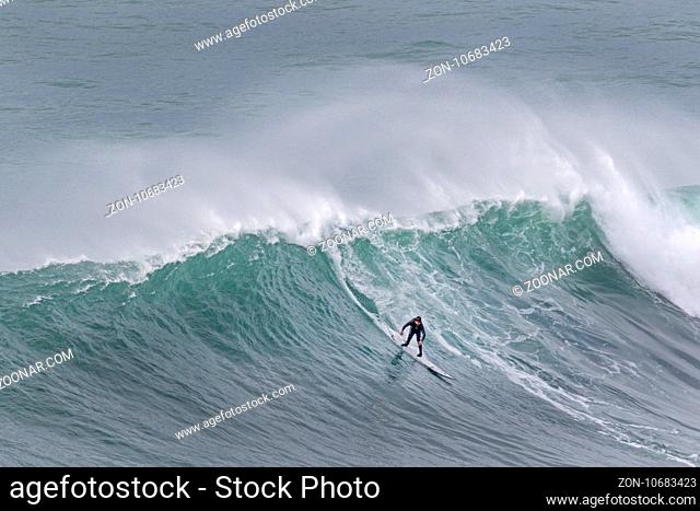 Surfer in einer Welle, Nazare, Portugal, Europa / Surfer on surf board riding wave, Nazare, Portugal, Europe