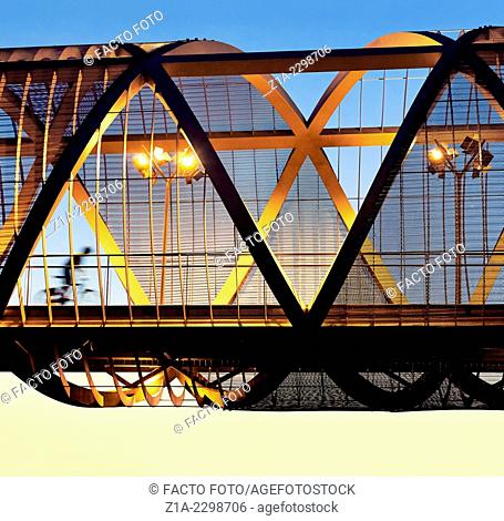 Cyclist passing by the Arganzuela bridge, designed by architect Dominique Perrault. Madrid Rio Park. Madrid. Spain