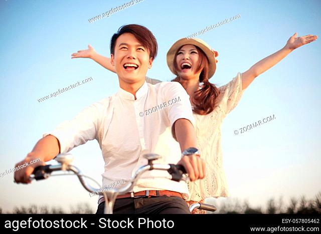 The young couple riding a bicycle high quality photo