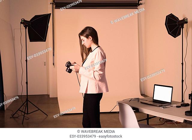 Side view of female model holding camera