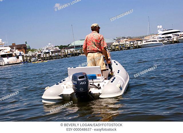 Man on a dinghy, small boat, with a motor on the Chesapeake Bay in Maryland, USA