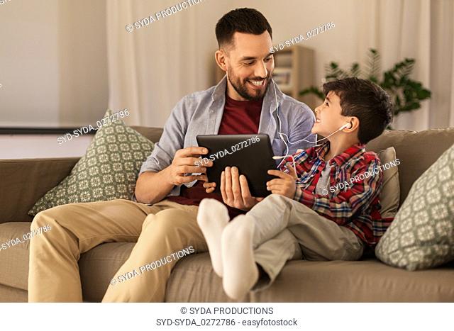 father and son listening to music on tablet pc