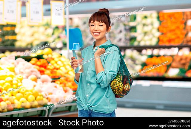 woman with food in string bag and glass bottle