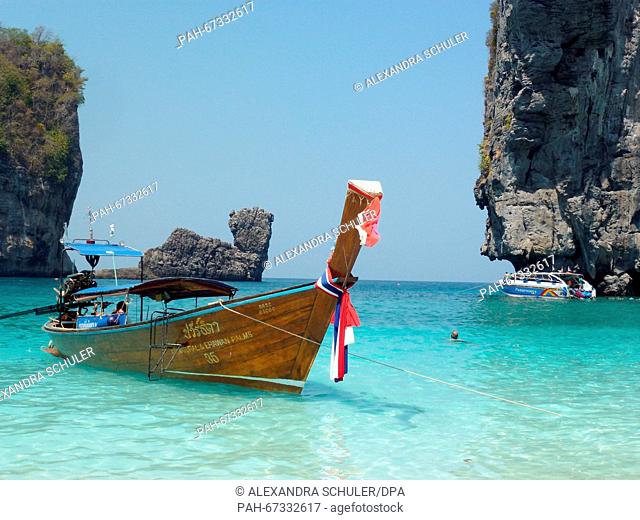 A Long-tail boat at Nui Bay on the island of Ko Phi Phi Don, Thailand, 10 March 2016. The 'Camel Rock' is seen in the background