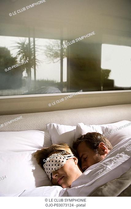Couple sleeping in bed together
