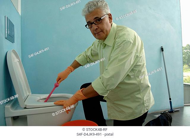 Senior man cleaning toilet