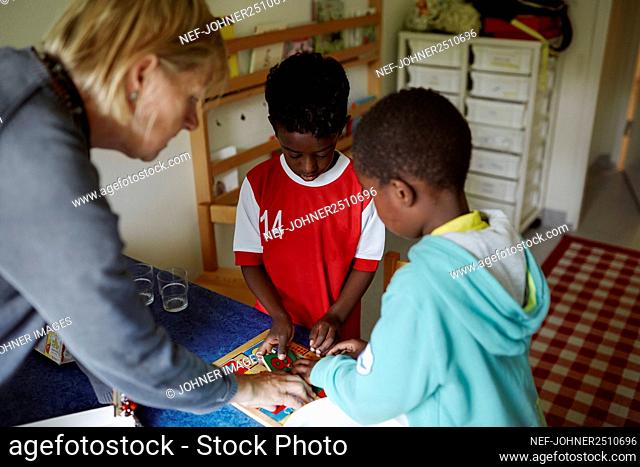 Teacher helping boys with puzzles