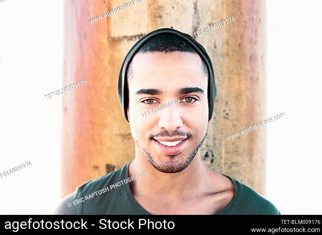 Smiling Hispanic man wearing cap