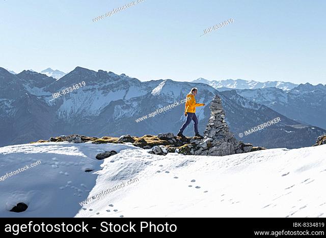 Mountaineer looks over snow-covered mountains, hiking to the Guffert, Brandenberg Alps, Tyrol, Austria, Europe