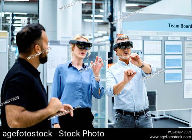 Coworkers using augment reality glasses at electrical industry