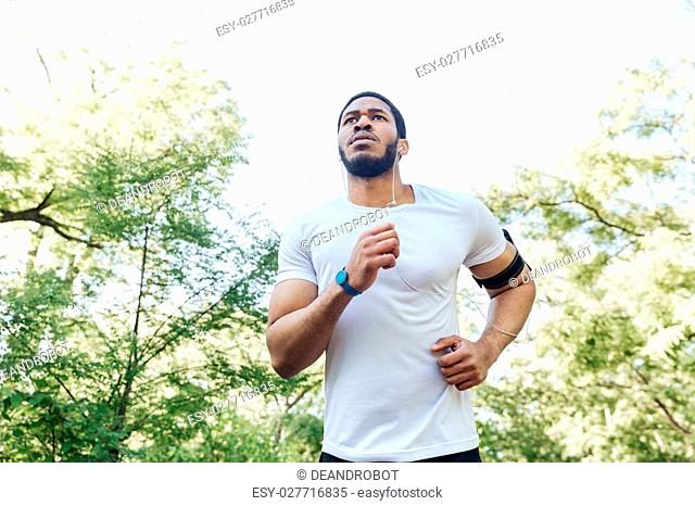 Focused african american young sportsman running outdoors