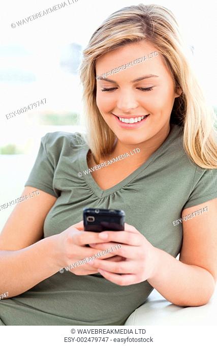 A closer shot of a woman using her phone as she smiles