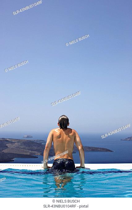 Man climbing out of infinity pool