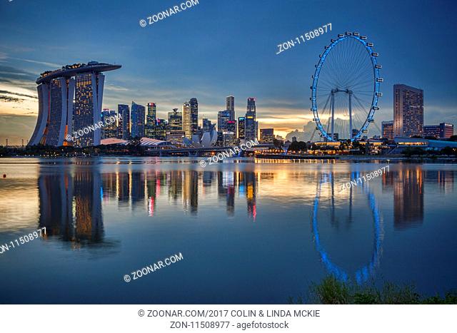 Singapore skyline with the Marina Bay Sands, the CBD and the Singapore Flyer, all reflected in Marina Bay and illuminated at twilight