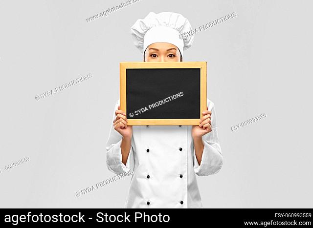 female chef holding black chalkboard