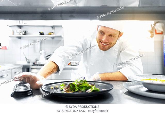 happy male chef cooking food at restaurant kitchen