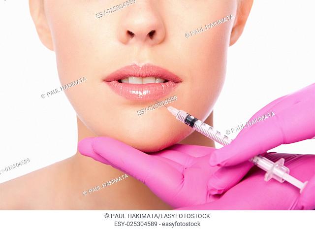 Beautiful plump lips injection with collagen filler Cosmetic spa beauty treatment with pink gloves, on white