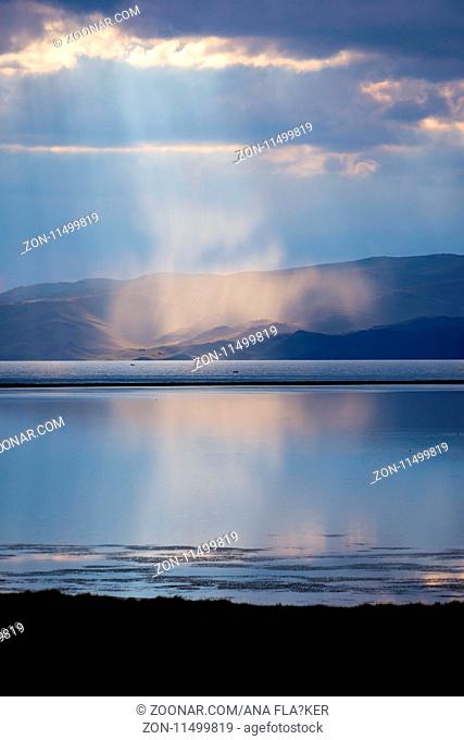 Storm with sun rays over beautiful mountains by Song Kul lake, Kyrgyzstan