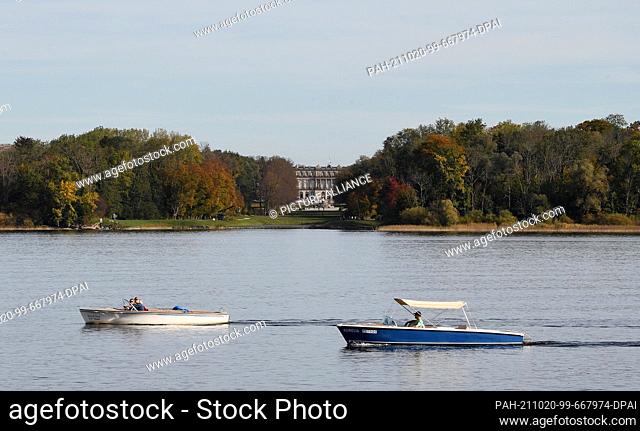 20 October 2021, Bavaria, Prien Am Chiemsee: On boats the summer temperatures of 20 degrees at the Chiemsee are enjoyed, in the background the castle...