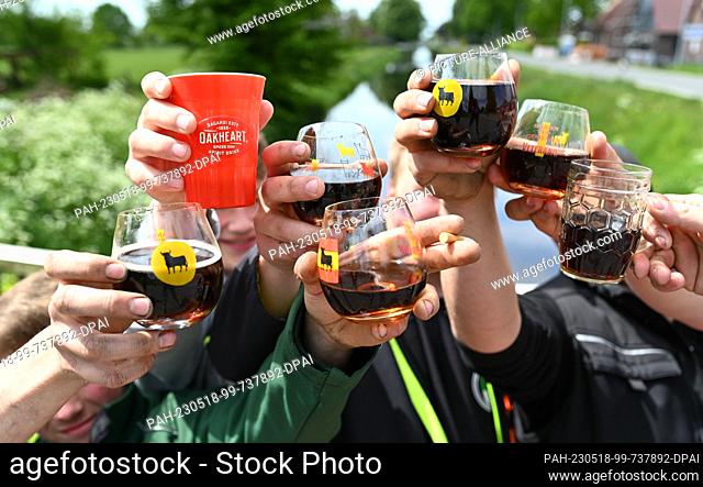 18 May 2023, Lower Saxony, Hesel: A group of young men toast Father's Day 2023 with full glasses. Ascension Day is a church holiday celebrated on the 40th day...