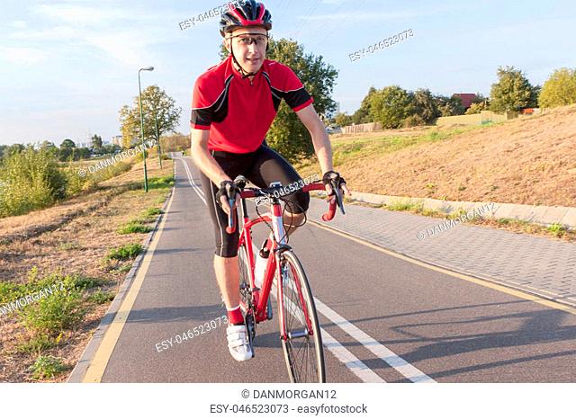 Portrait of Professional Caucasian Male Road Cyclist Having His Training Outdoors. Going Uphill. Horizontal Image Composition