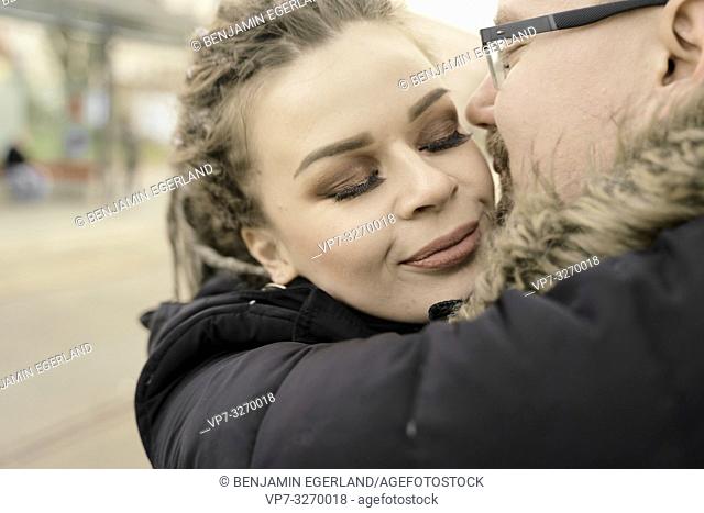 woman in arms of boyfriend at train station, couple in love, in inner city Cottbus, Brandenburg, Germany