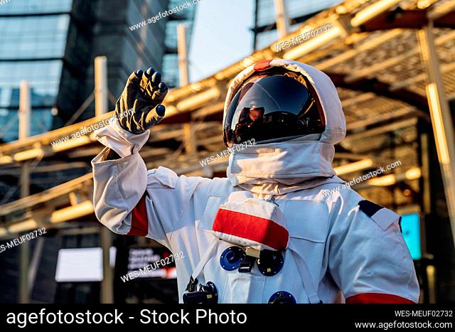 Male astronaut wearing space suit looking away