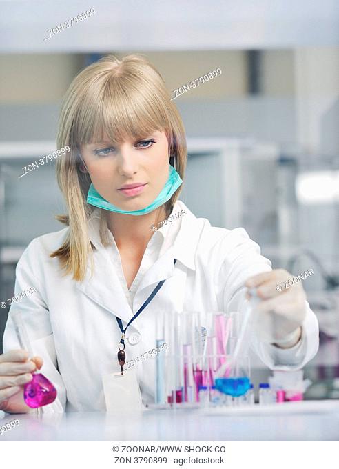 doctor student female researcher holding up a test tube in chemistry bright labaratory
