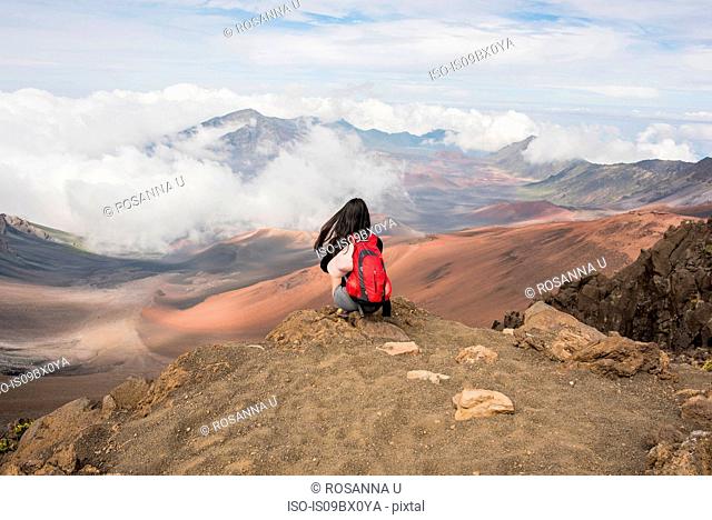 Hiker on edge of mountain top, Haleakala National Park, Maui, Hawaii