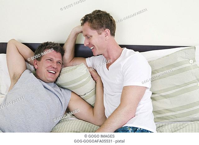 Gay couple talking in bed