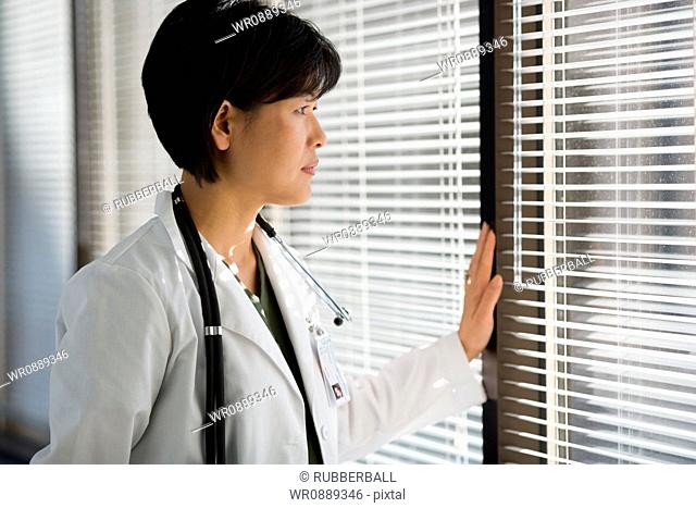Close-up of a female doctor looking through a window