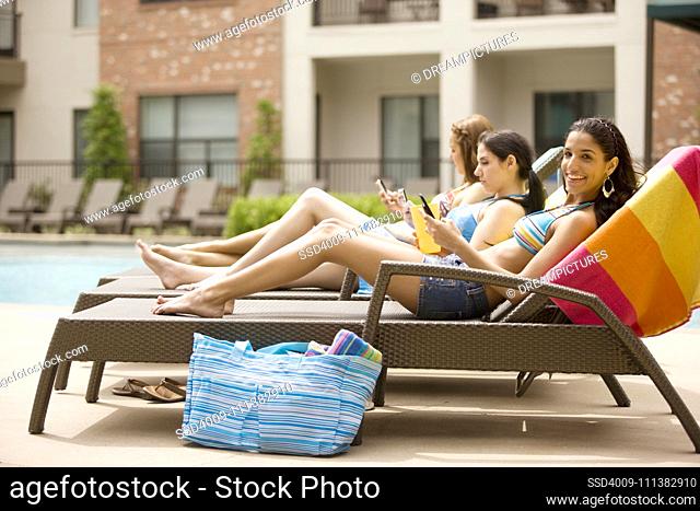 Women sitting in chairs at poolside