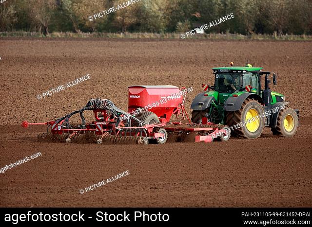 05 November 2023, Saxony-Anhalt, Derenburg: A farmer fertilizes his field with a tractor. Farmers use the weather to prepare their fields for spring