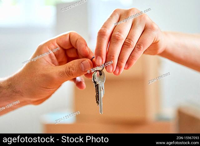 Zwei Hände bei Schlüssel Übergabe für das neue Haus oder die Eigentumswohnung