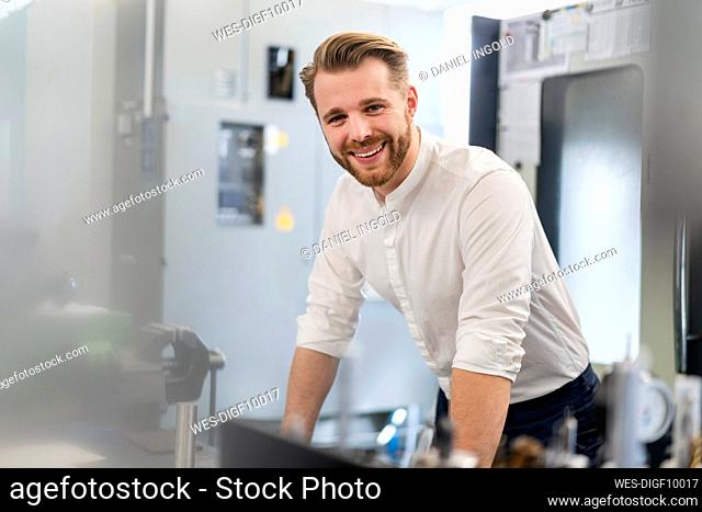 Portrait of a happy young man in a factory